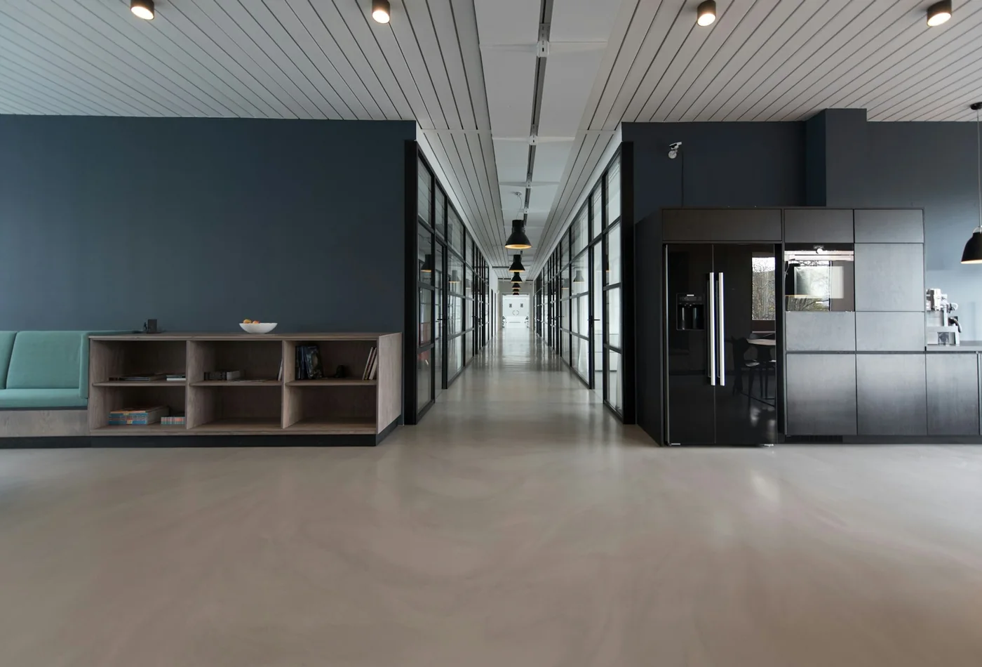 &Ouml;ppet kontor med betonggolv, vita v&auml;ggar och ribbat innertak