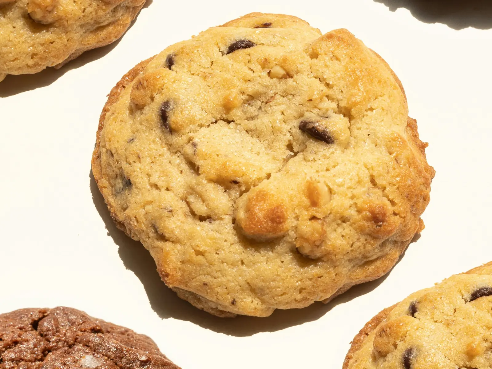 SMULA bageri (demo) 1 Fyra stora chocolate chip cookies på ljus botten, fotograferade rakt uppifrån